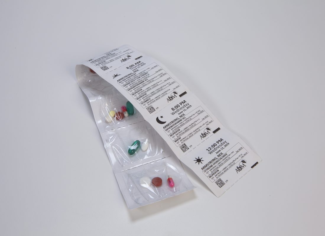 A strip of sealed medication pouches, each printed with the resident name, date and administration time.